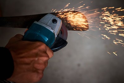 A worker cutting metal with a knife