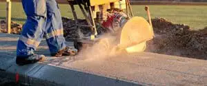 A man cutting through concrete with a diamond saw machine