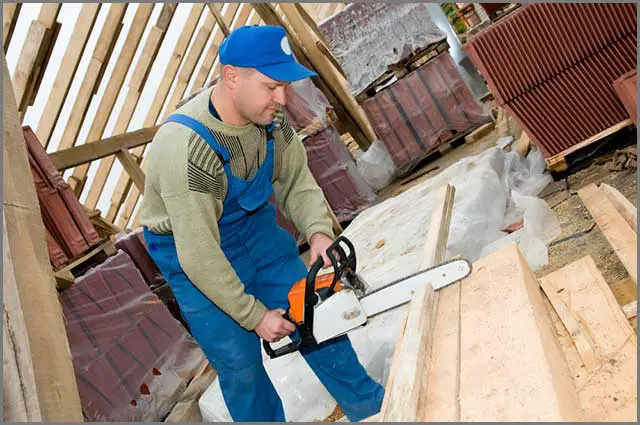 (man cutting timber using portable saw