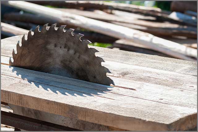 Man working with a circular saw blade and has his protective gears on.
