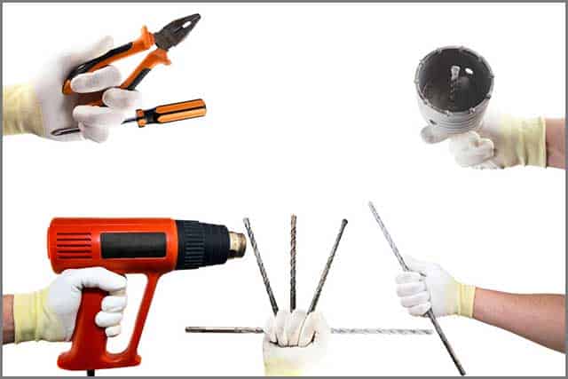 Different construction tools in the hands in white gloves