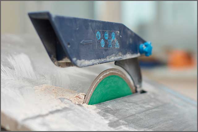  A tile saw blade midway through cutting a porcelain tile