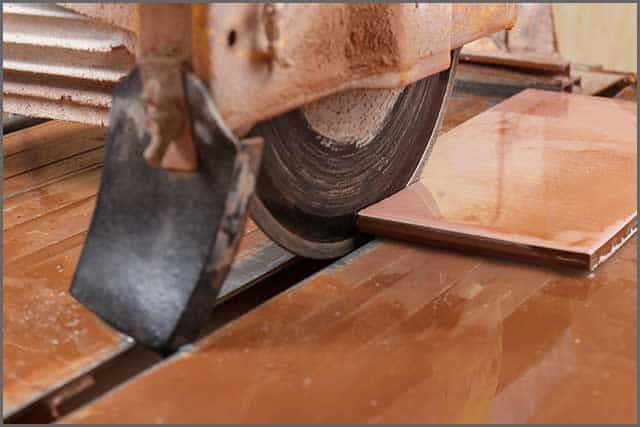 Image of a tile saw blade cutting a ceramic tile.