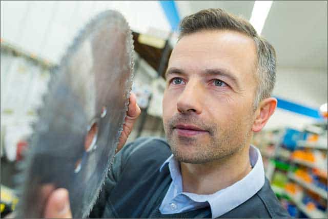 a man checking out a circular saw blade he wants to buy.