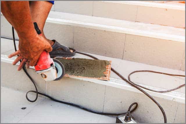 Image of a man working with a handheld saw.
