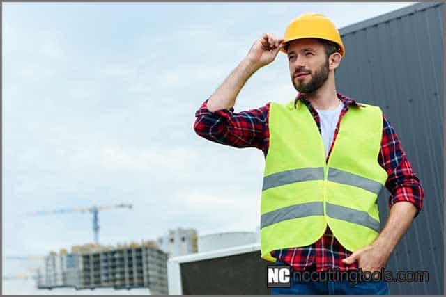 A guy wearing a safety vest and a helmet