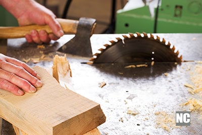 A carpenter working with a table saw to cut wood