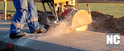 A road construction worker repairing concrete cracks