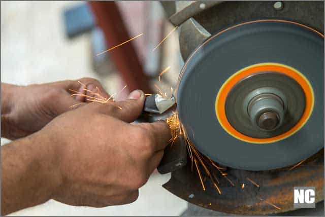 A machine operator dressing a grinding wheel with dressing too