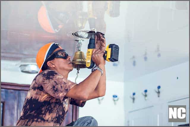 Handyman using a Hole saw to the borehole in the ceiling