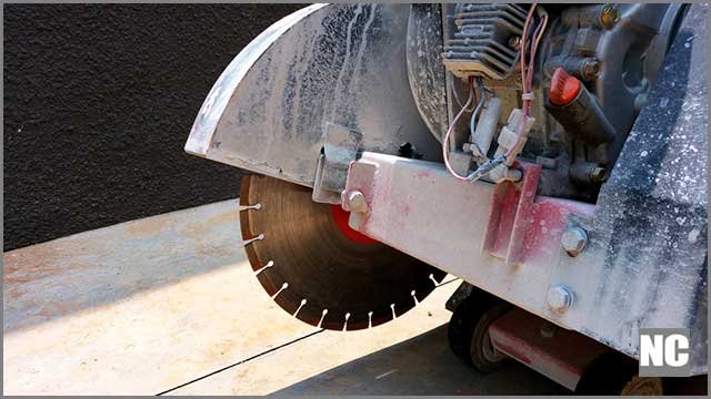 A man cutting concrete paving with a diamond saw blade