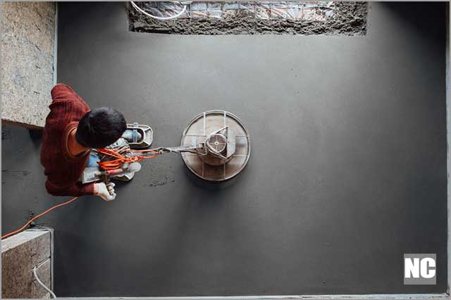 Top view of final grinding of the concrete floor by a construction worker