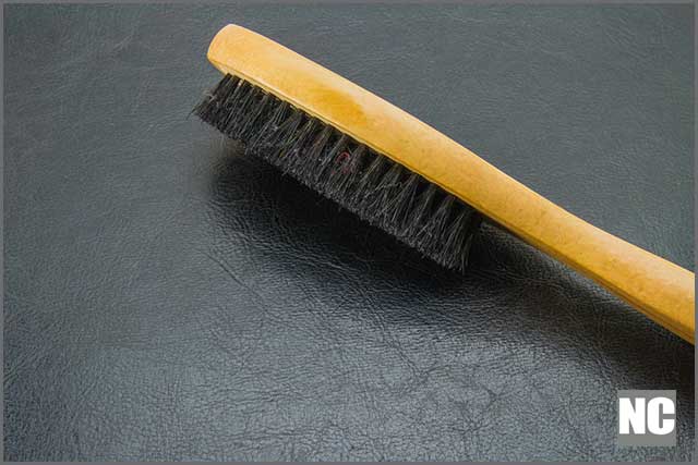 Plastic bristle brush for pad cleaning during and after polishing