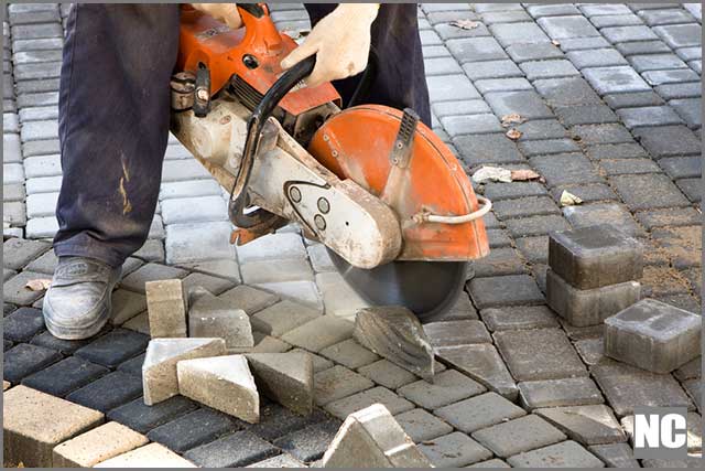 A worker cutting through a concrete wall