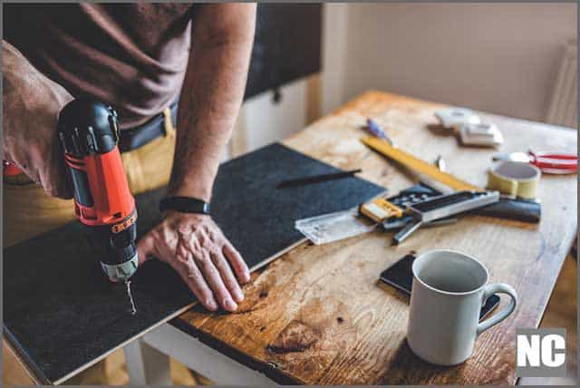 A person drilling laminate with a power drill