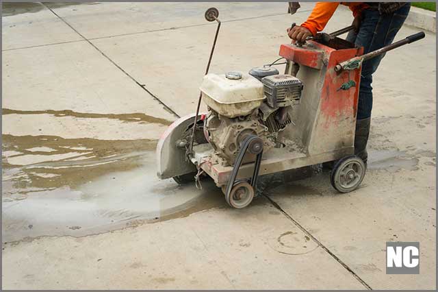 A worker cutting through a concrete wall