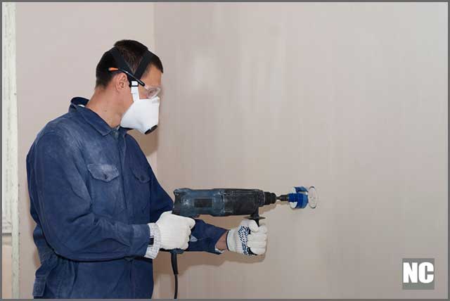 An electrician drilling a reinforced conc6