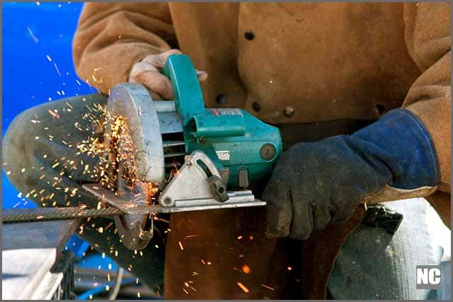 Operator wearing a glove and other protective wears as he cuts metal