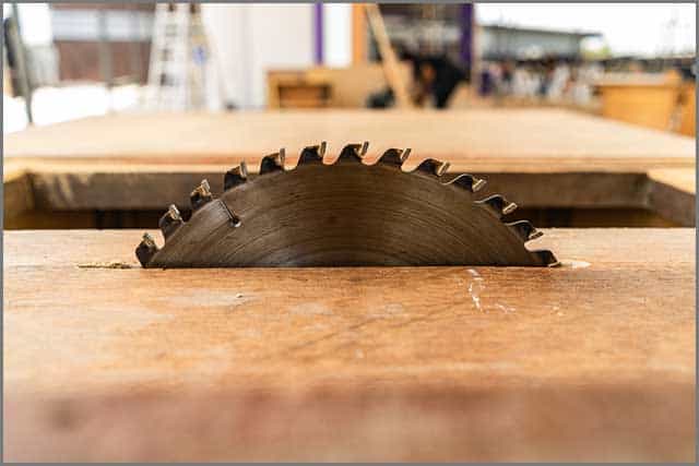A cutting blade slicing through a wooden table