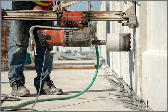 A construction worker using a suitable tool to cut concrete