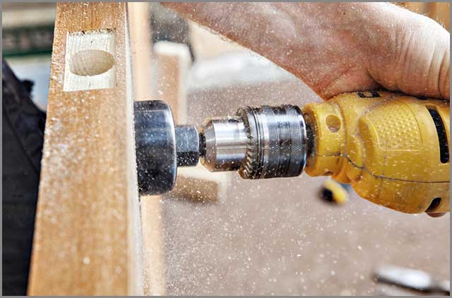 Drilling a big hole through the doorknob using an electric drill