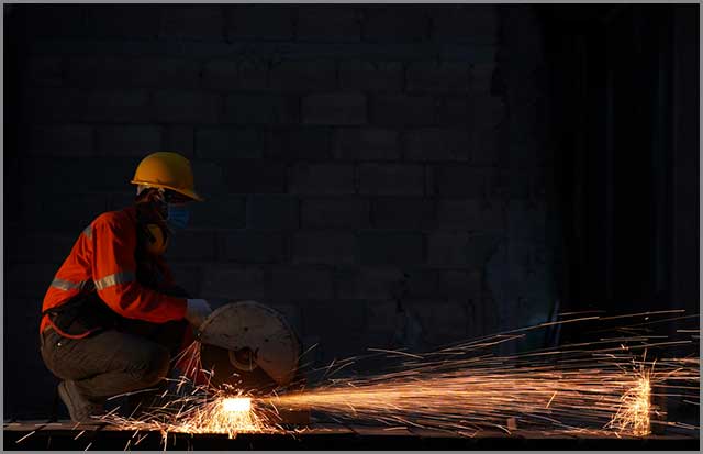 Picture showing a man on safety gear while cutting metal