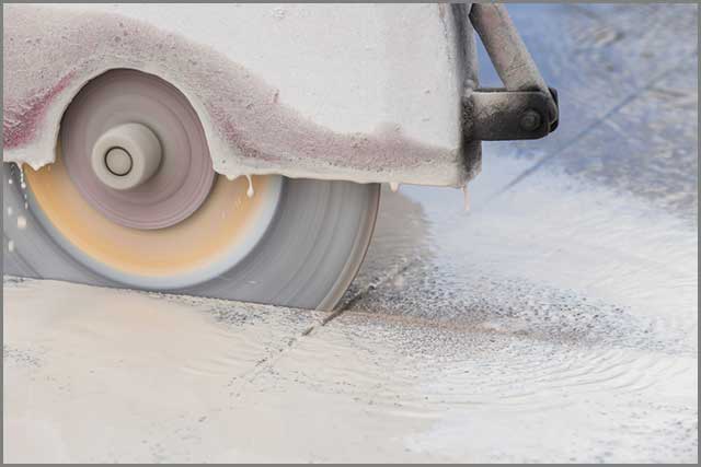 A worker cutting concrete with a diamond saw