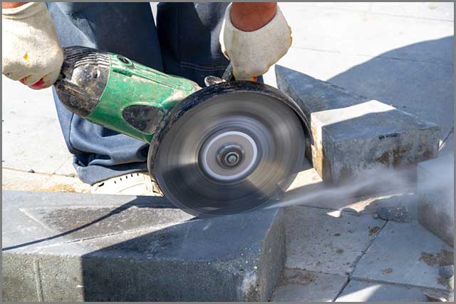 An electric saw cutting stone