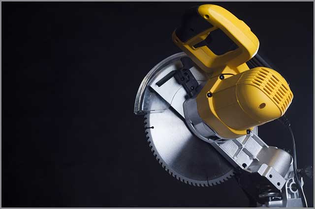 A compound miter saw on a black background