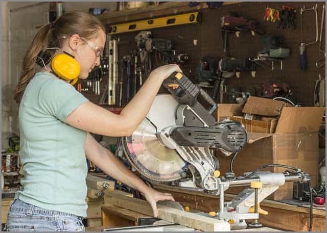 A carpenter working with a dual-compound sliding miter saw