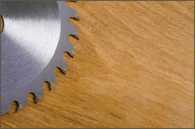 A Table Circular Saw Blade on a Wooden Background
