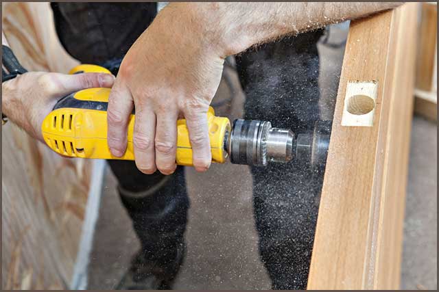 A handyman Drilling A Wooden Plank