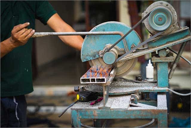 A technician holding a single bevel miter saw