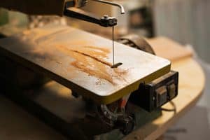A scroll saw showing its table and blade