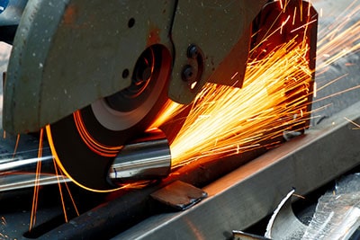 A worker using a saw to cut