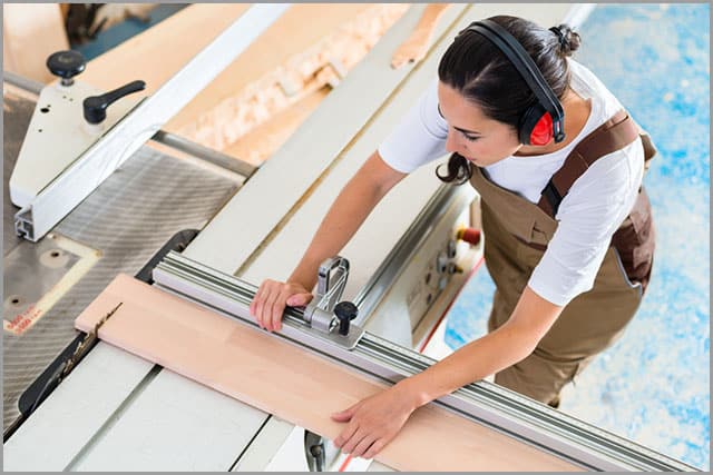 A professional performing cross-cutting with a rip fence.