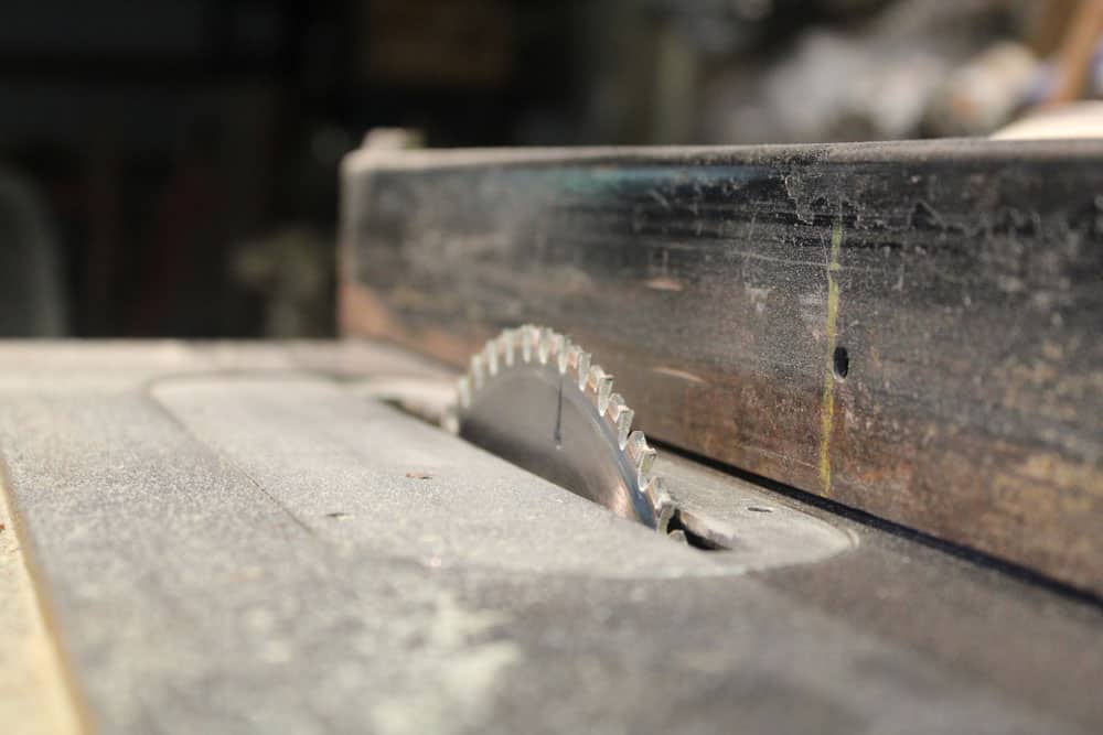 A closeup of a table saw blade and fence