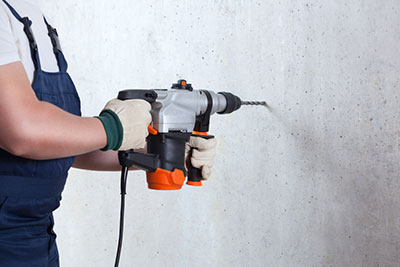 An operator holding a hammer drill