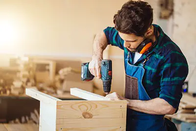 Carpenter Drilling Wood with a Cordless Drill