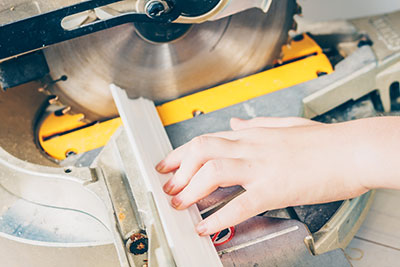 A boy is cutting polystyrene foam using a crosscut saw