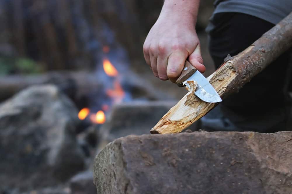 Using a hunting knife to carve timber
