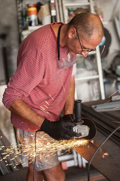 A working cutting metal using an angle grinder