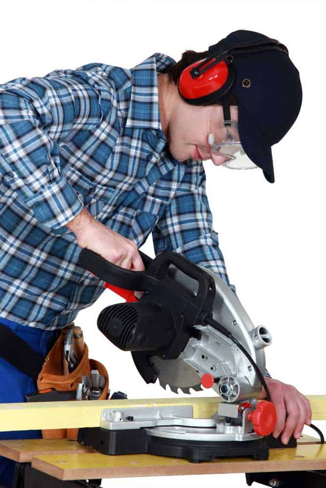 Woodworker using a miter saw.