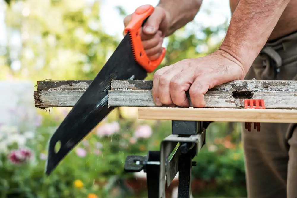 A woodworker working with a hand saw